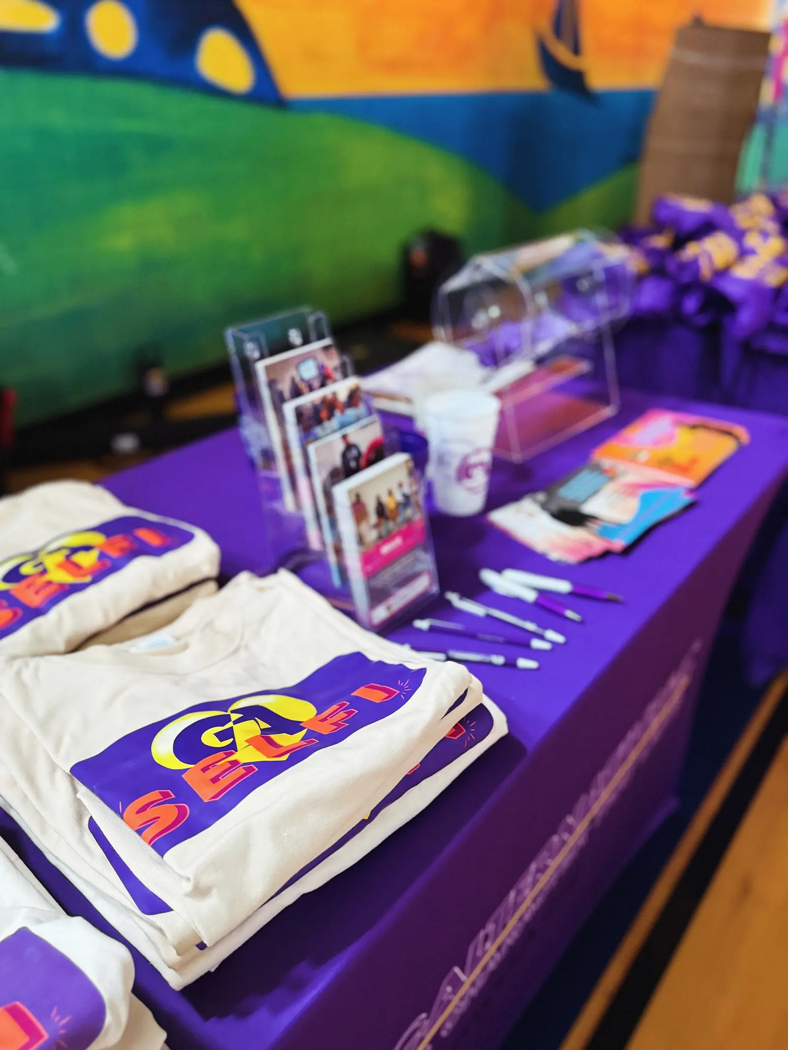 Folded shirts and printed cards laid out on a table for a distribution.
