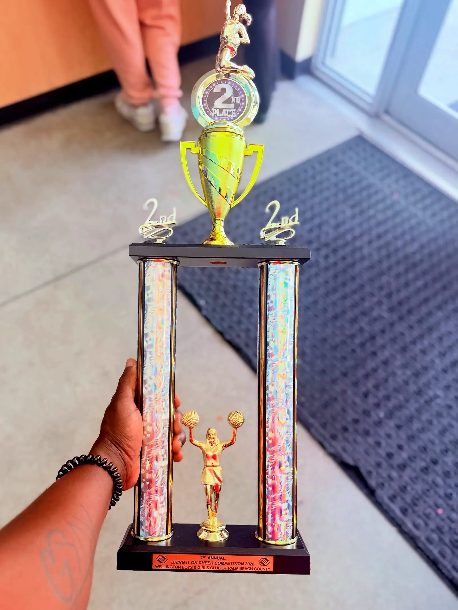 A hand holding a trophy at a community showcase.