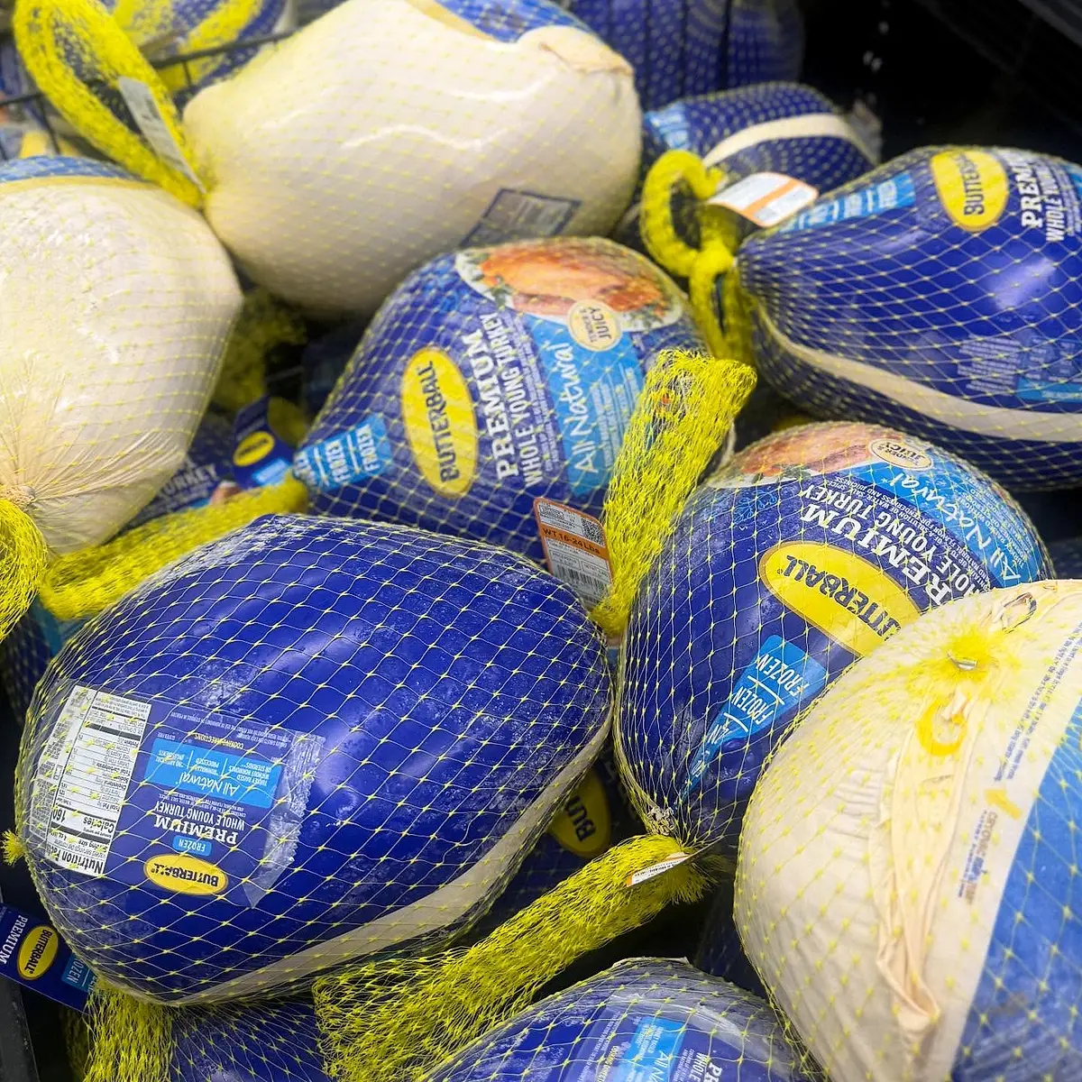 Close-up of blue mesh sacks of produce stacked together.