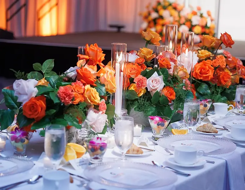 A banquet table laid with floral centrepieces, glassware and place settings.