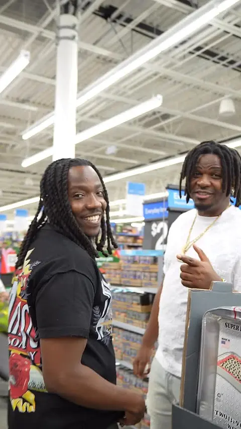 Two people standing in a shop aisle among shelves of boxed toys.